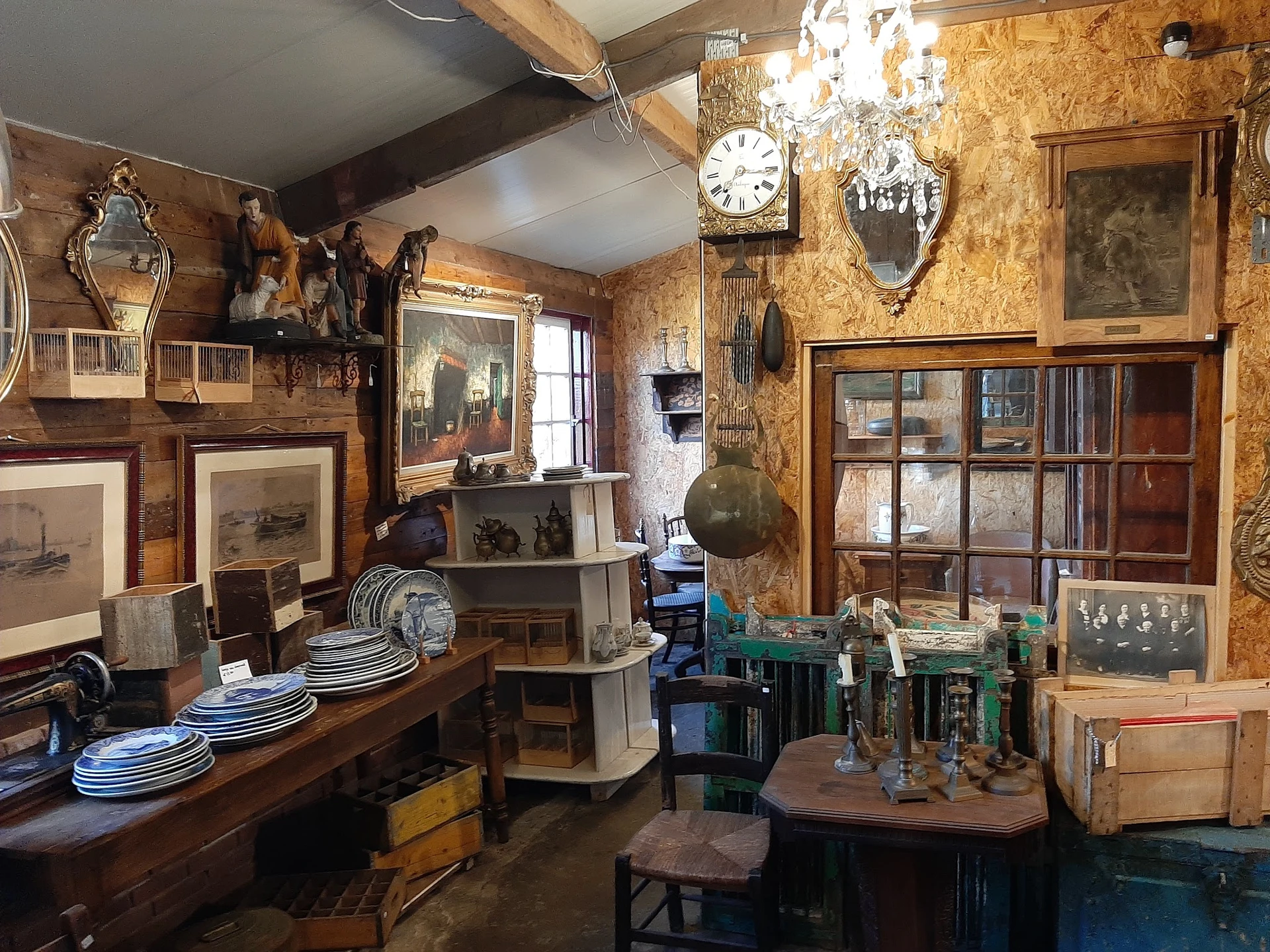 Vintage winkelinterieur vol antieke meubels, schilderijen, klokken, servies en decoratieve voorwerpen