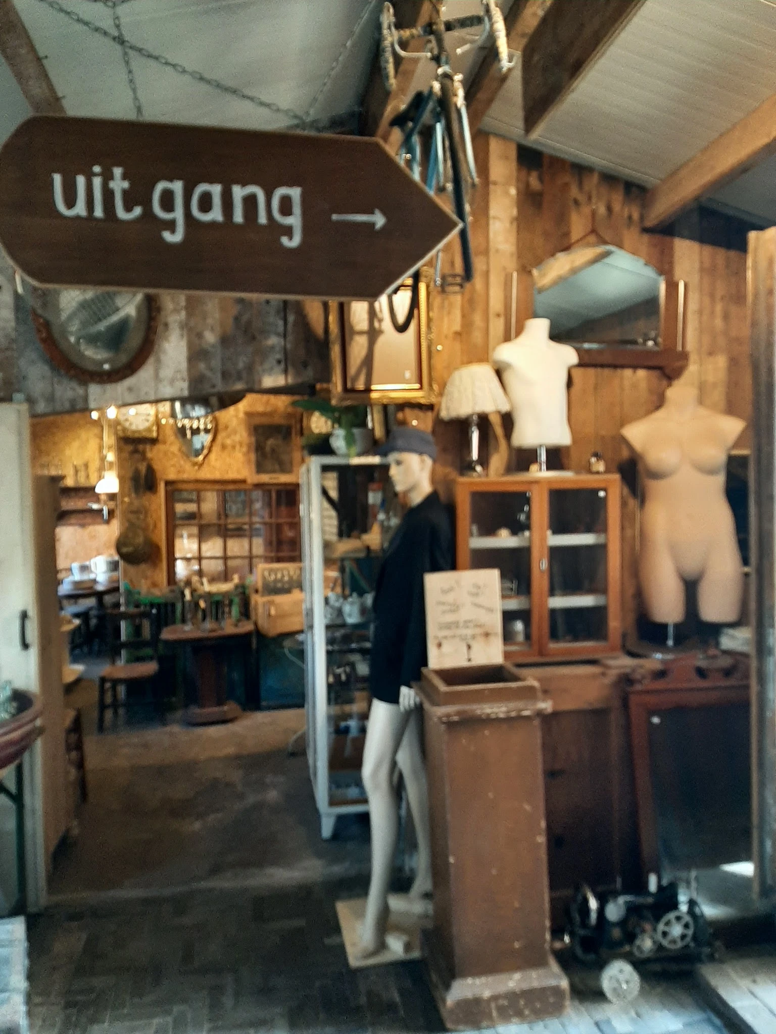 Vintage winkelinterieur met houten meubels, etalagepoppen, lampen en diverse tweedehands spullen