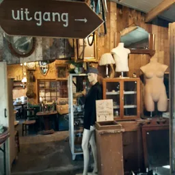 Vintage winkelinterieur met houten meubels, etalagepoppen, lampen en diverse tweedehands spullen