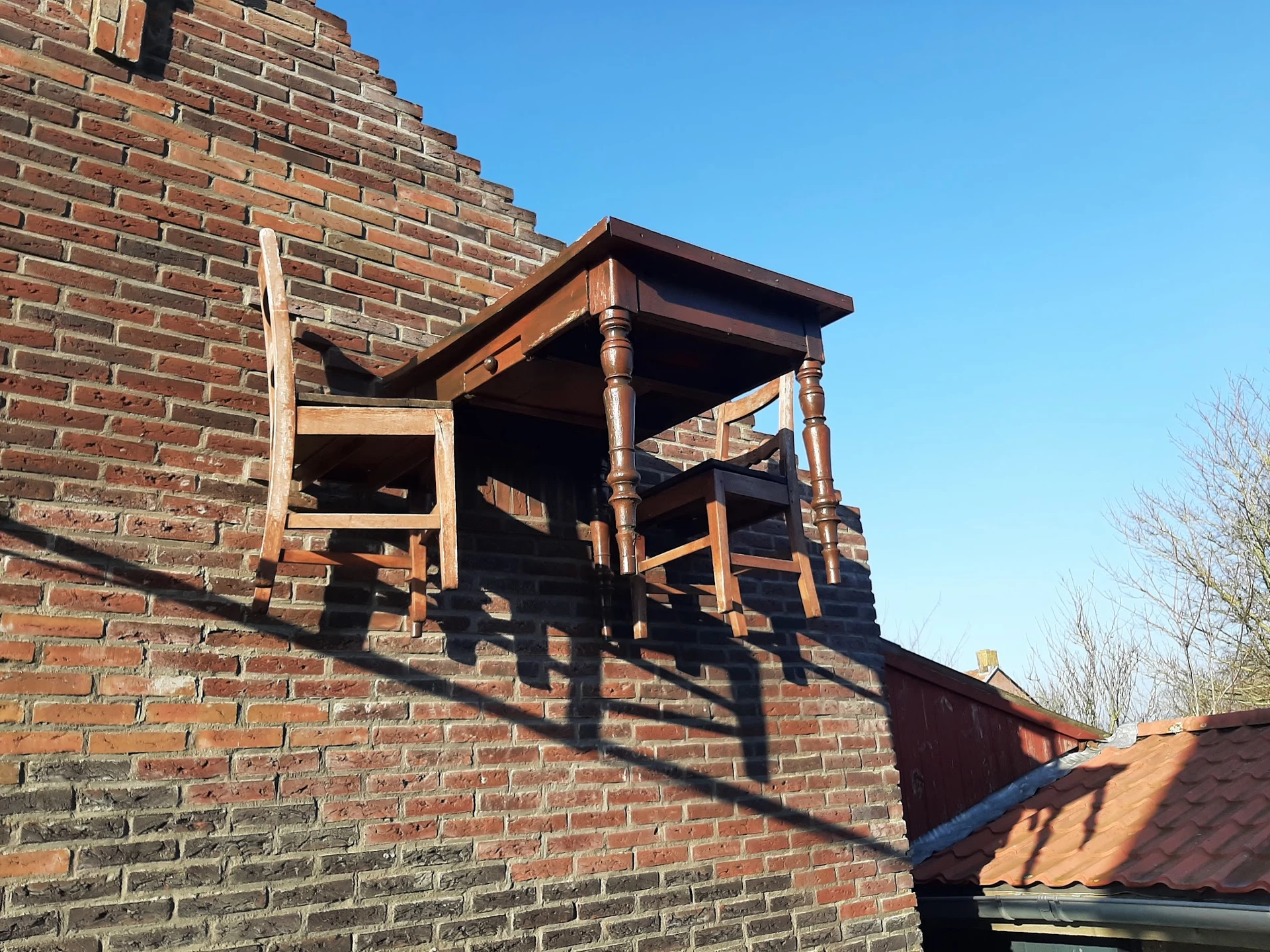 Bakstenen gevel met houten trap/constructie tegen de muur, tegen hemel