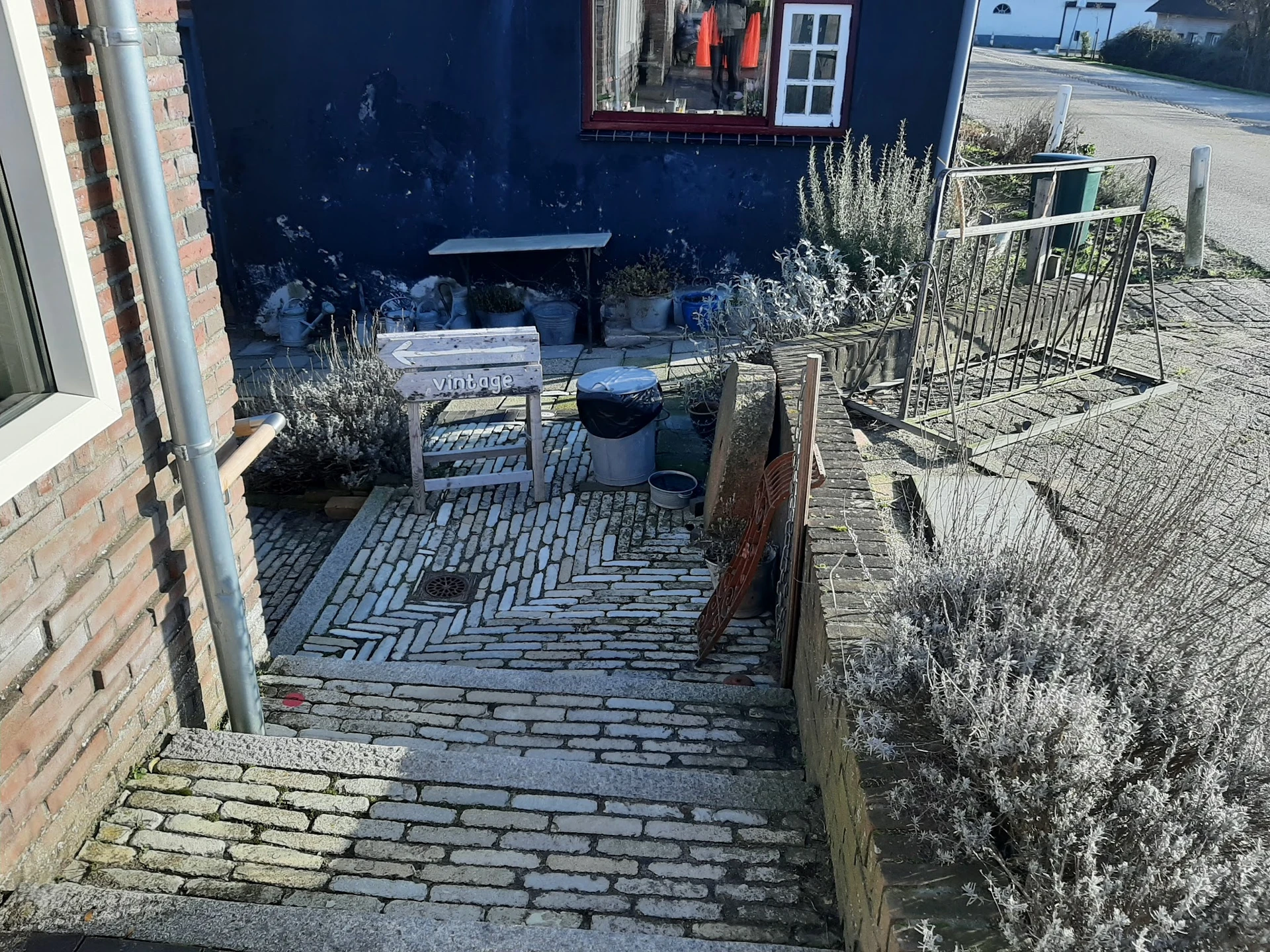 Binnenplaats of terras met herringbone-tegels, tuinmeubels en plantenbakken