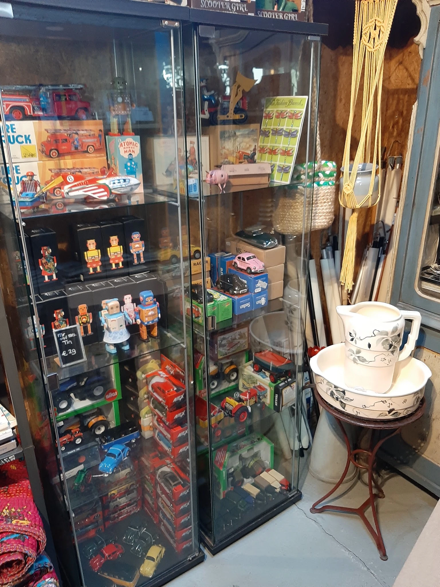 Vitrinekasten met vintage speelgoed, robots, auto's en ander collectibilia uitgestald