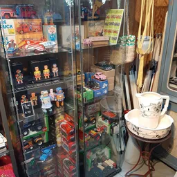 Vitrinekasten met vintage speelgoed, robots, auto's en ander collectibilia uitgestald