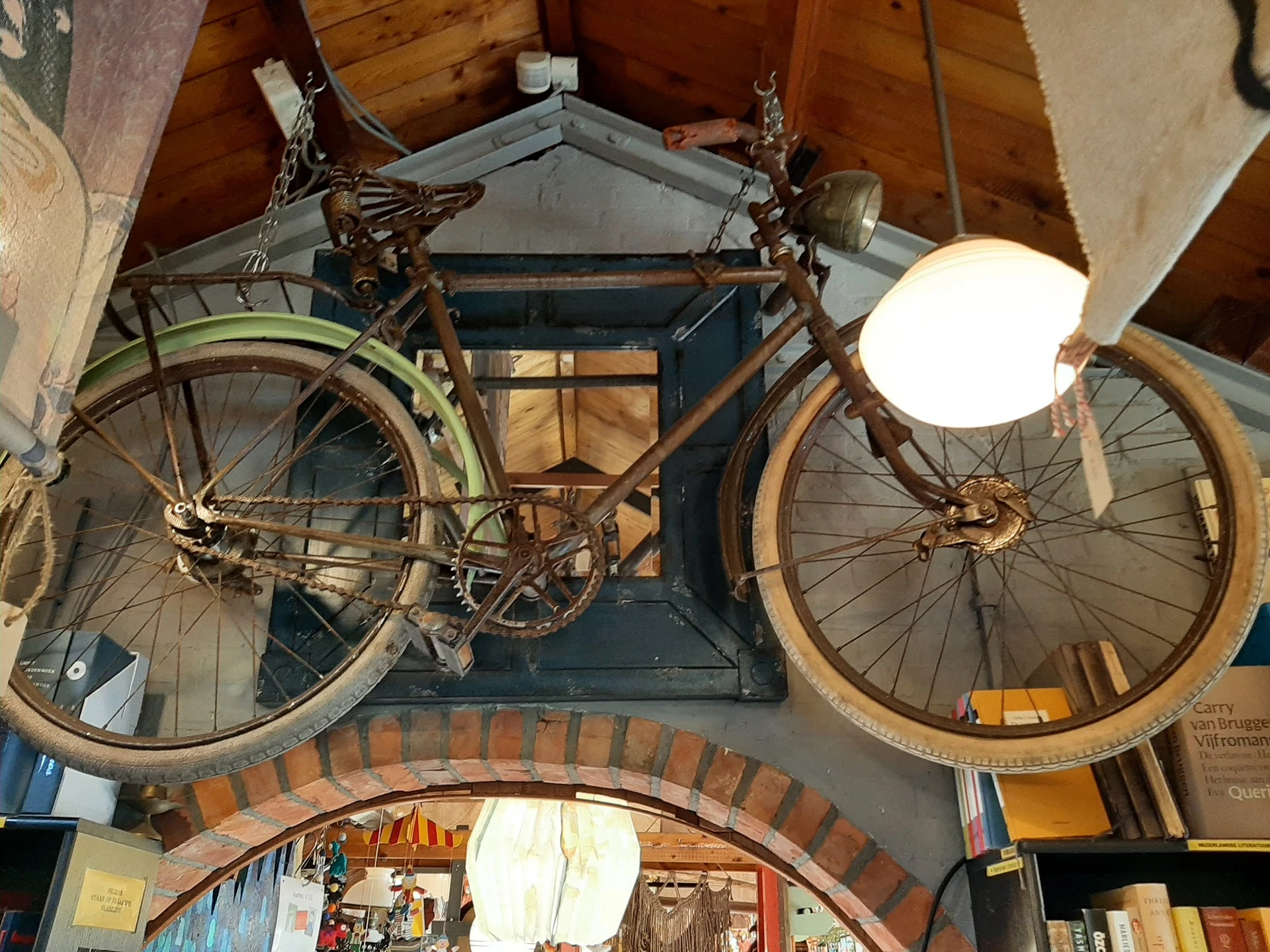 Twee vintage fietsen opgehangen aan een muur als decoratie in de winkel