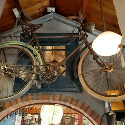 Twee vintage fietsen opgehangen aan een muur als decoratie in de winkel