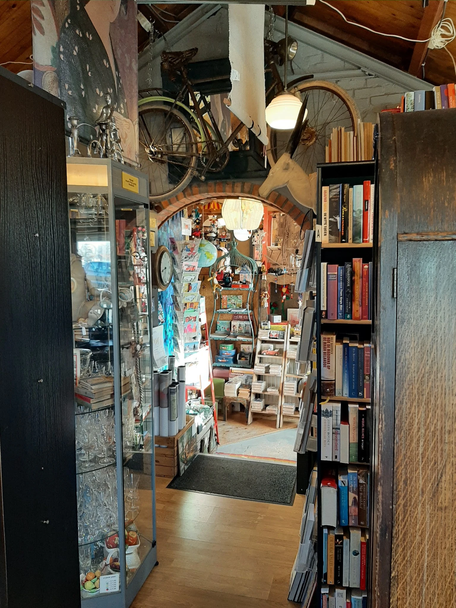 Smalle winkelruimte met boekenkasten, vintage spullen en posters aan de muren