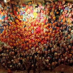 Groot aantal vintage poppen en speelgoed aan de muur in de winkel opgesteld