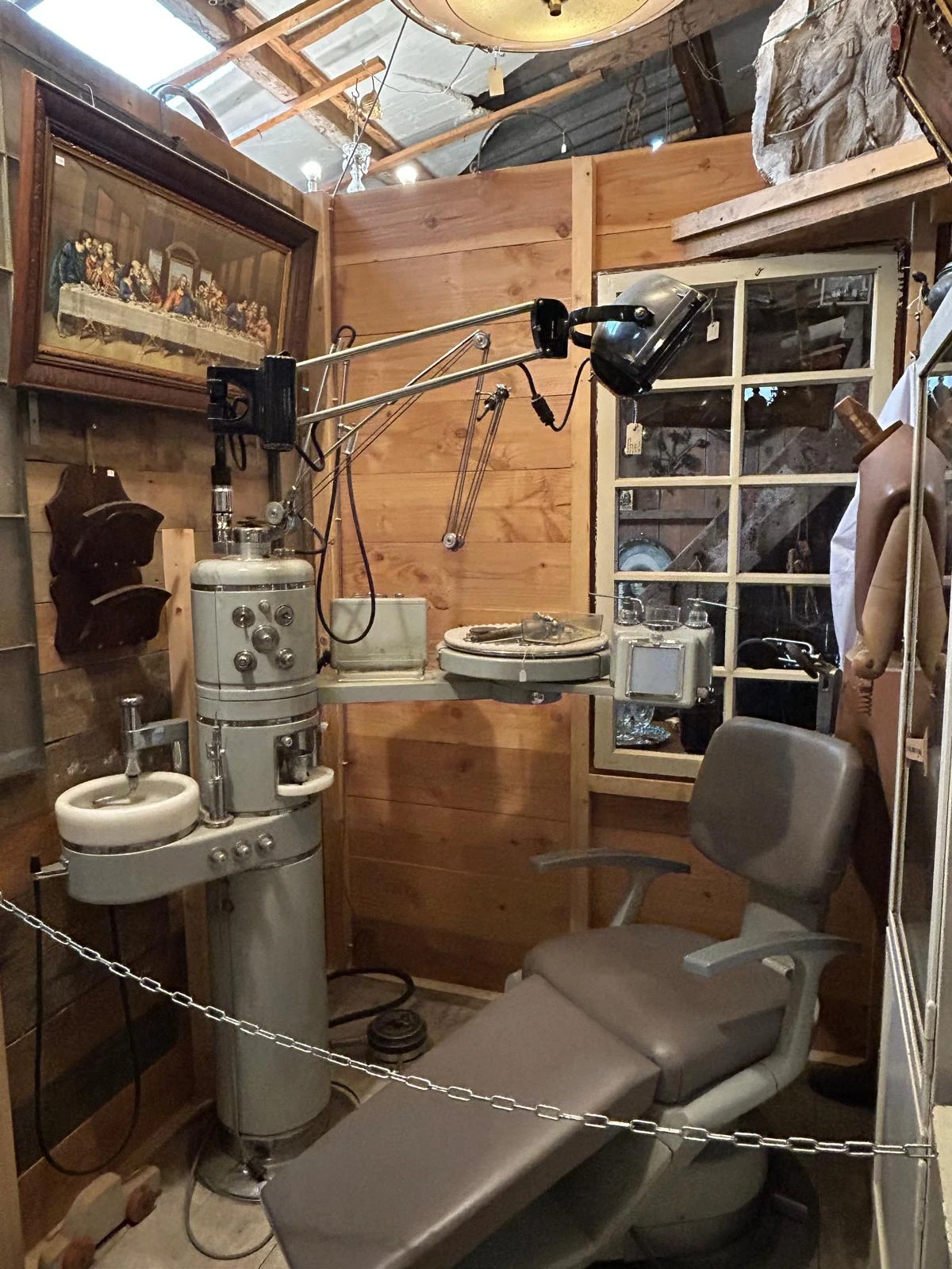 Vintage tandartsstoel en instrumenten in een winkelhoek met houten wanden en stellingen