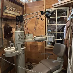 Vintage tandartsstoel en instrumenten in een winkelhoek met houten wanden en stellingen
