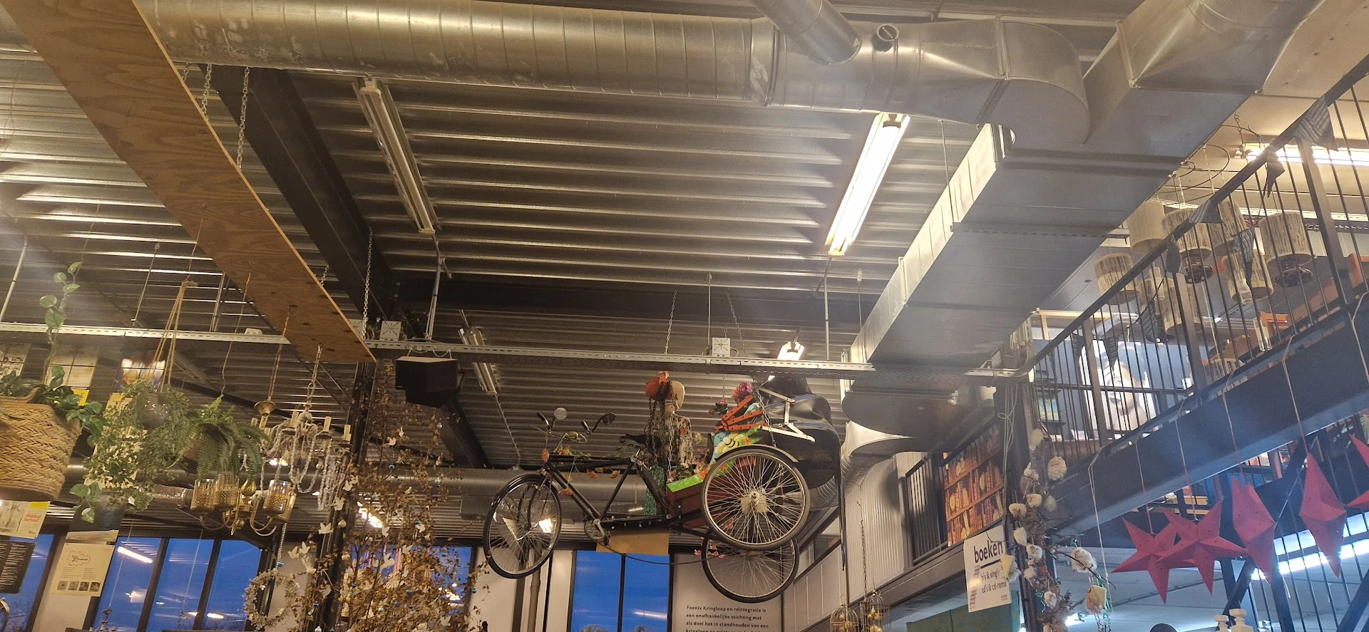Tweedehands fietsen opgehangen aan het plafond in een kringloopwinkel