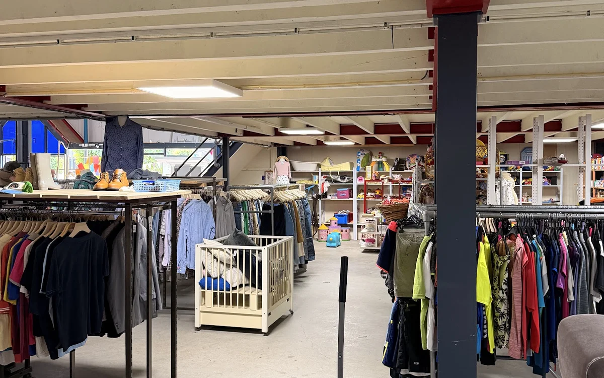 Winkelvloer met kledingrekken en een centrale kolom, overzicht van het tweedehands aanbod