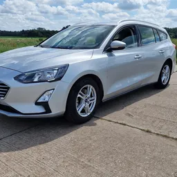 Witte Ford Focus stationwagen op parkeerplaats, volzijde aanzicht