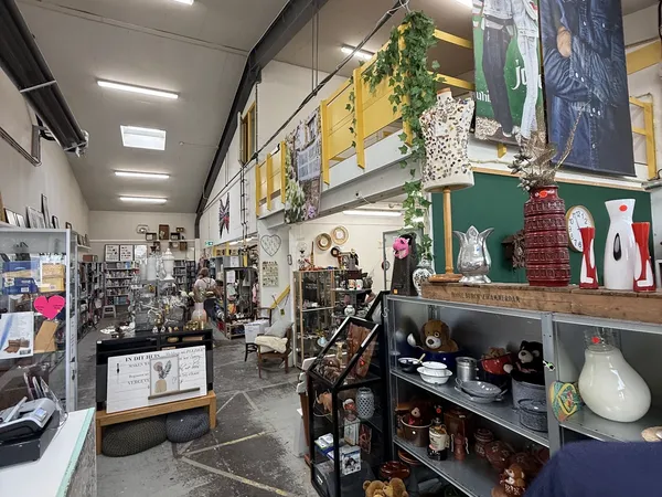 Winkelvloer met stellingen vol decoratieartikelen, servies, kunstvoorwerpen en huishoudelijke spullen