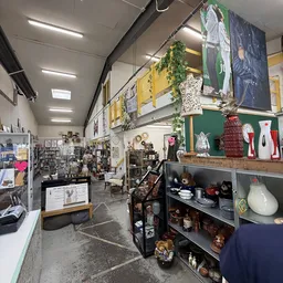 Winkelvloer met stellingen vol decoratieartikelen, servies, kunstvoorwerpen en huishoudelijke spullen