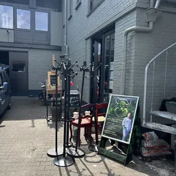 Binnenterrein met decoratieve objecten, een zwart metalen kunstwerk, een affiche en vintage items