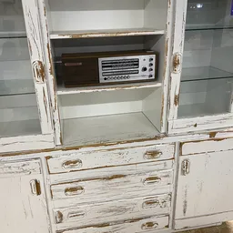 Vintage kastje met glasedeuren en lades met daarin een oude radio-tuner