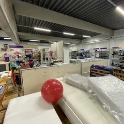 Winkelvloer met stellingen, toonbanken en uiteenlopende artikelen in een kringloopwinkel