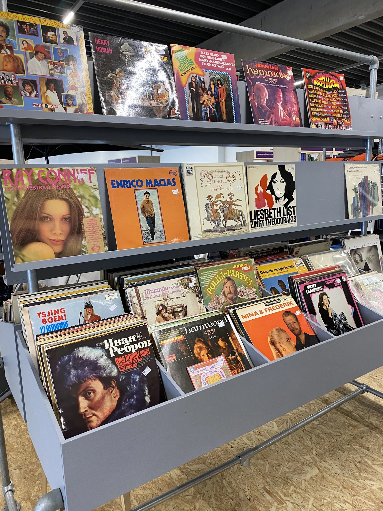 Uitgestalde vinyl LP's en platen op stellingen, met albums van diverse artiesten zichtbaar