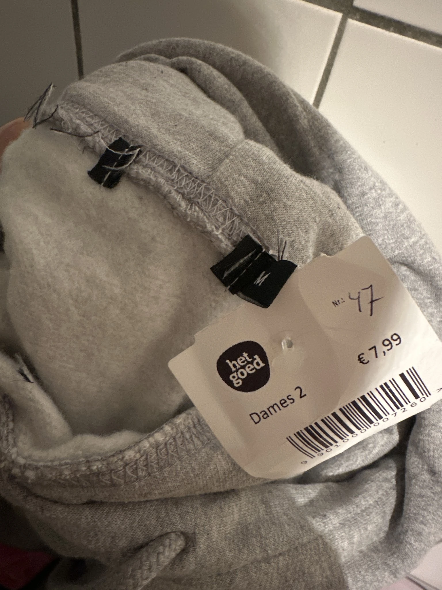Grijze trui met prijskaartje van €7,99 en artikelnummer 47