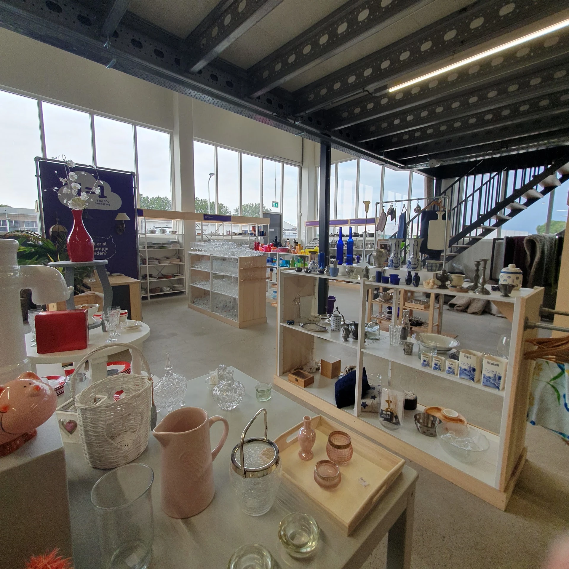 Winkelvloer met houten toonbanken en stellingen vol met huishoudelijke spullen en decoratieartikelen