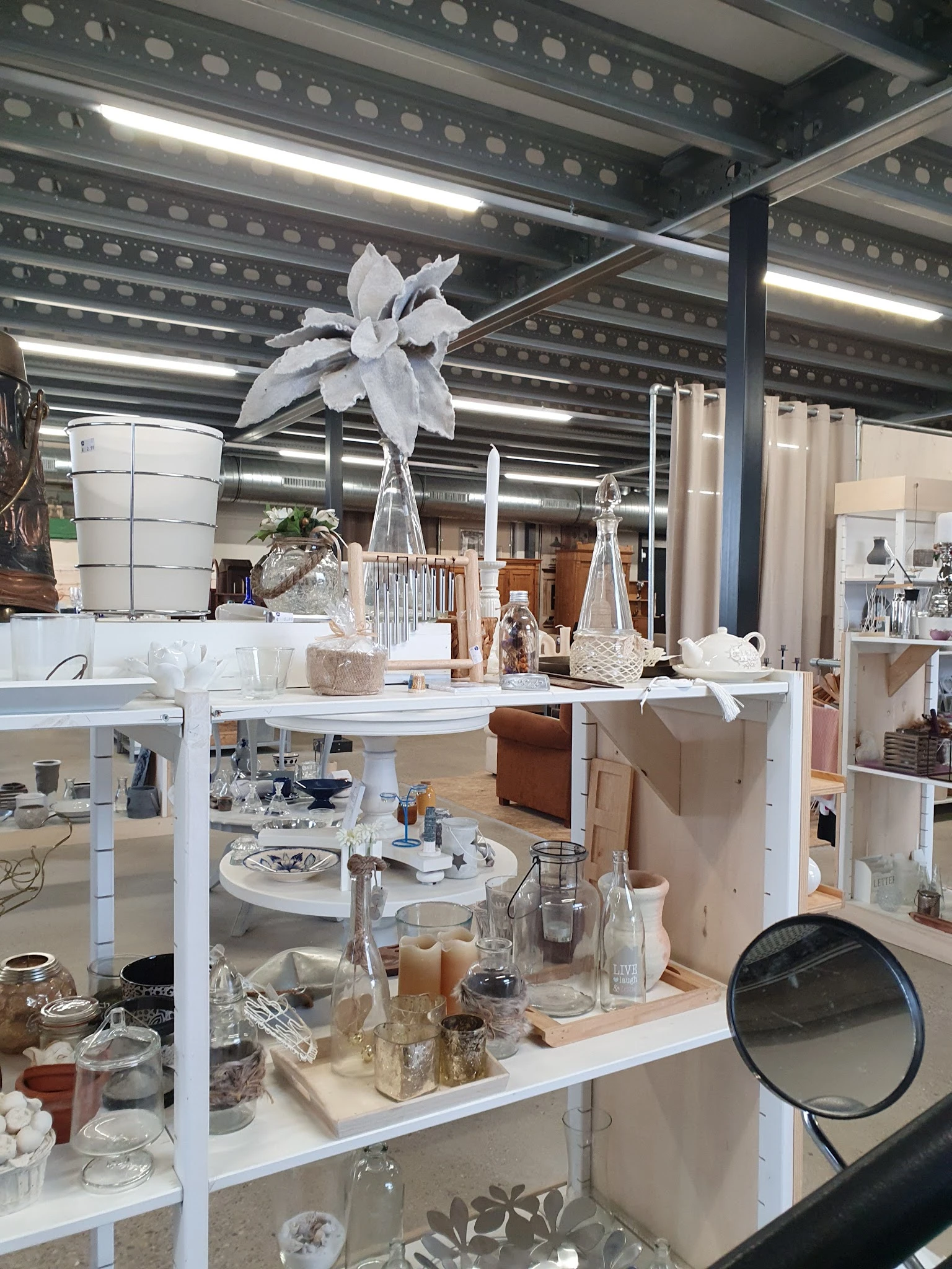 Vitrinekast met huishoudartikel, decoratie, kaarsen en accessoires uitgestald op verschillende niveaus