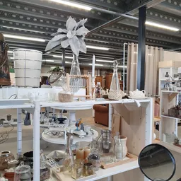 Vitrinekast met huishoudartikel, decoratie, kaarsen en accessoires uitgestald op verschillende niveaus