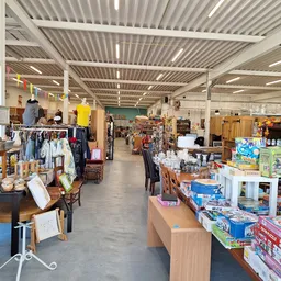 Overzicht van de winkelvloer met verschillende afdelingen: kleding, boeken, huishoudspullen en ander vintage- en tweedehandsa