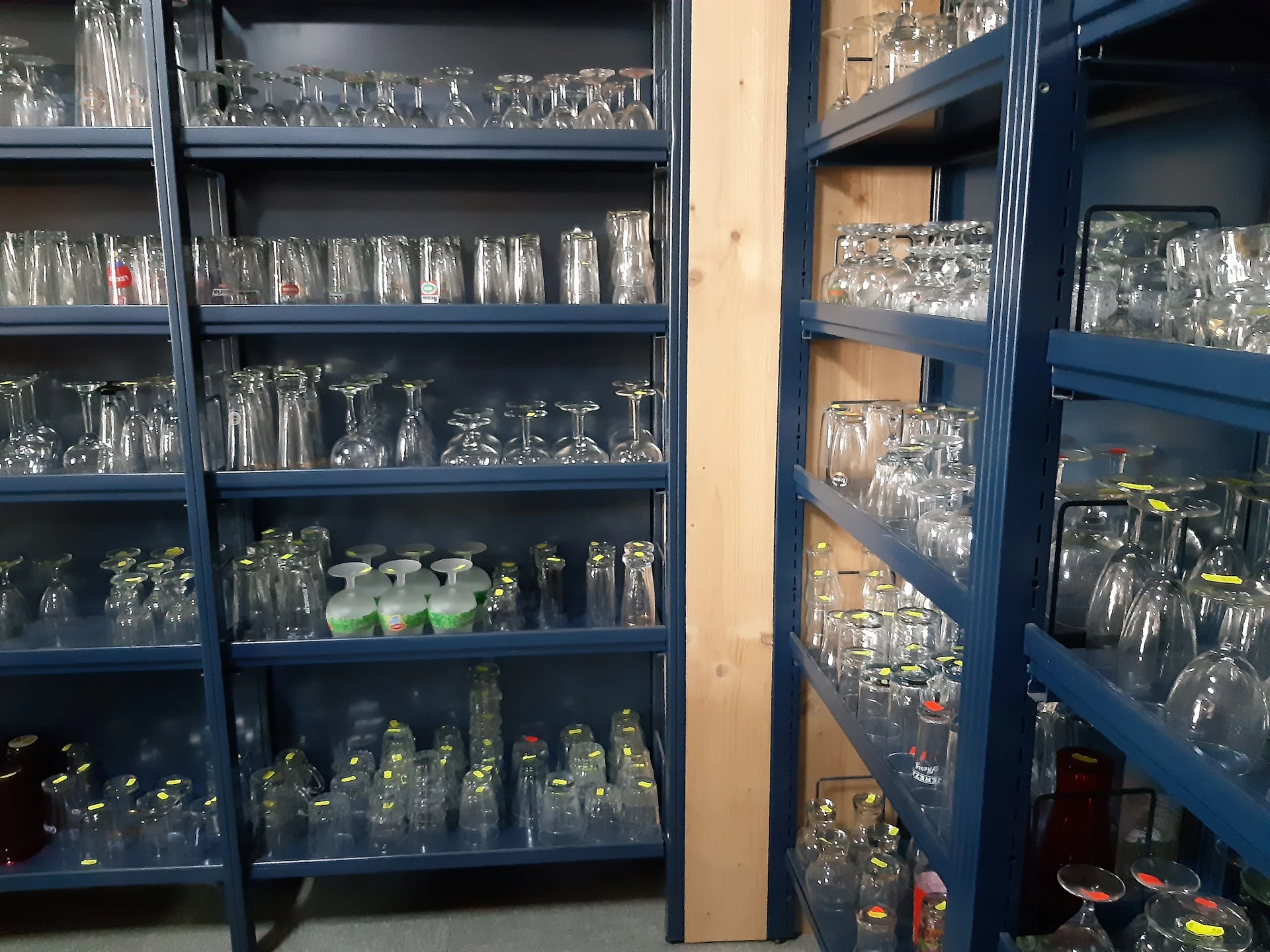 Glazen kasten met veel verschillende glazen, kannen en serviesgoed netjes uitgestald