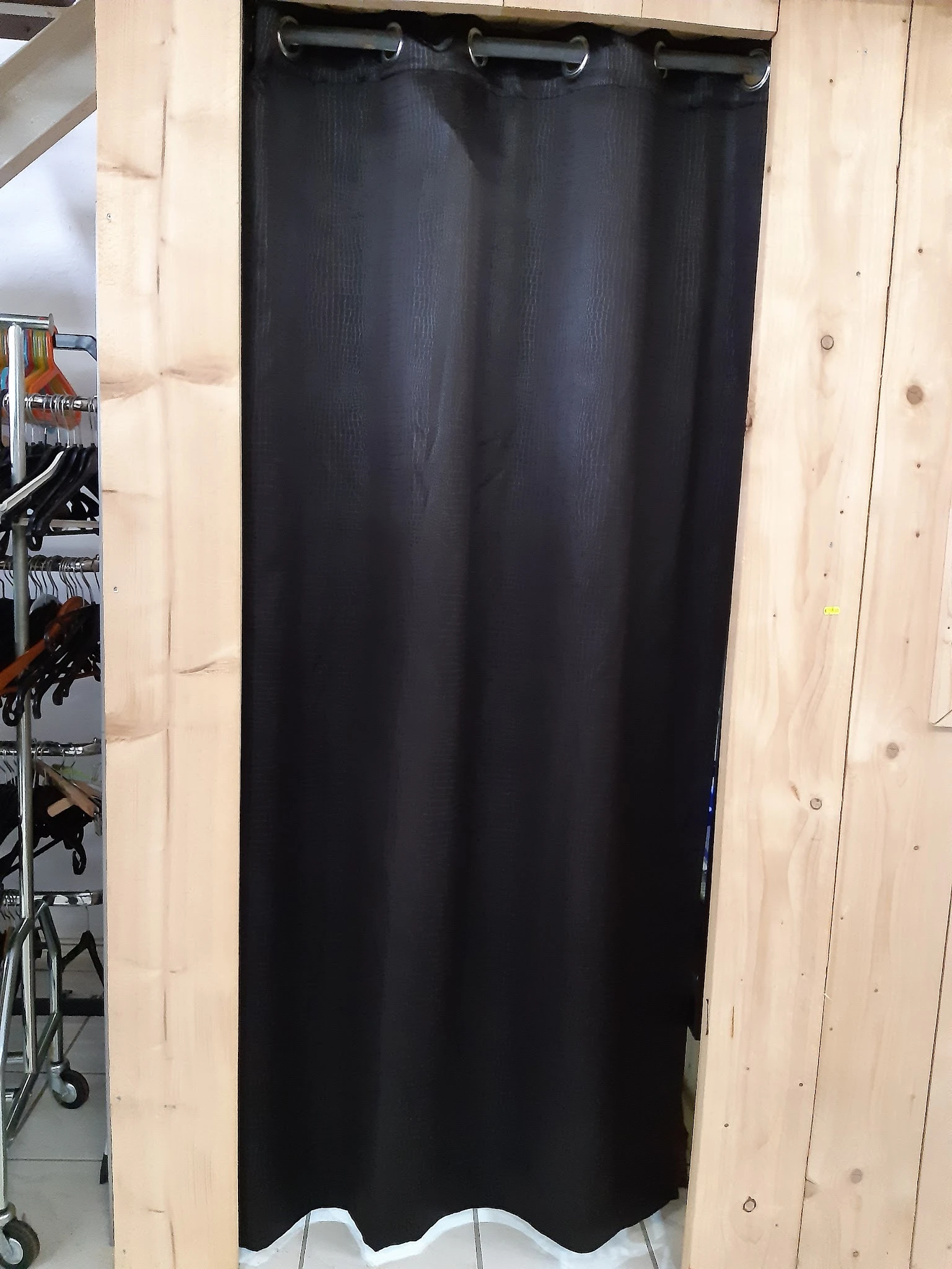 Zwart gordijn of textiel uitgestald tegen houten wand in winkel