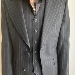 Close-up van een grijze nette blazer met krijtstreep en witte knoppen