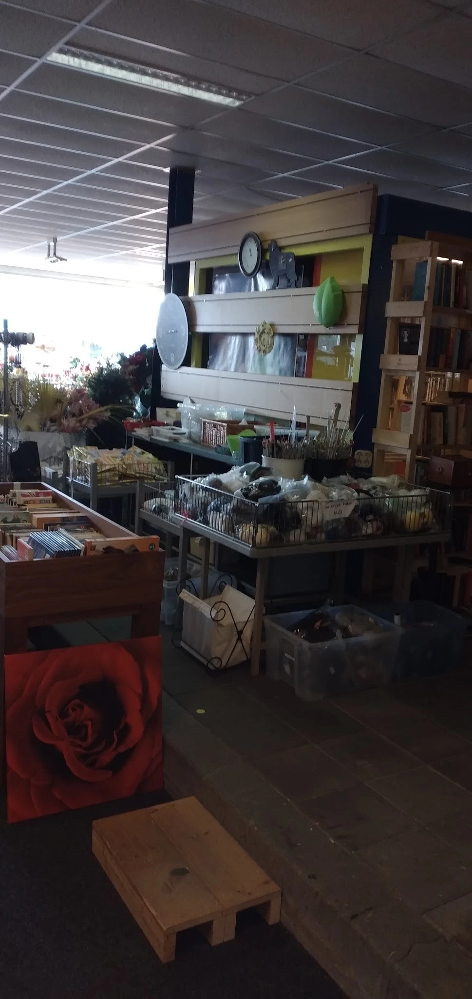 Overzicht van winkelinterieur met stellingen, dozen en spullen, weinig zichtbaar door slechte belichting