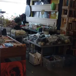 Overzicht van winkelinterieur met stellingen, dozen en spullen, weinig zichtbaar door slechte belichting