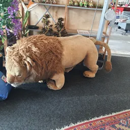 Groot bruin pluchen speelgoed in leeuwvorm, uitgestald in de winkel