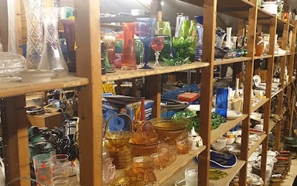 Houten stellingkasten vol met diverse spullen en huishoudartikelen in een kringloopwinkel