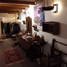 Winkelinterieur met uitgestalde kleding, meubels en decoratie onder sfeervolle verlichting