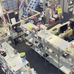 Overzicht van een kringloopwinkel met toonbanken, stellingen en diverse spullen