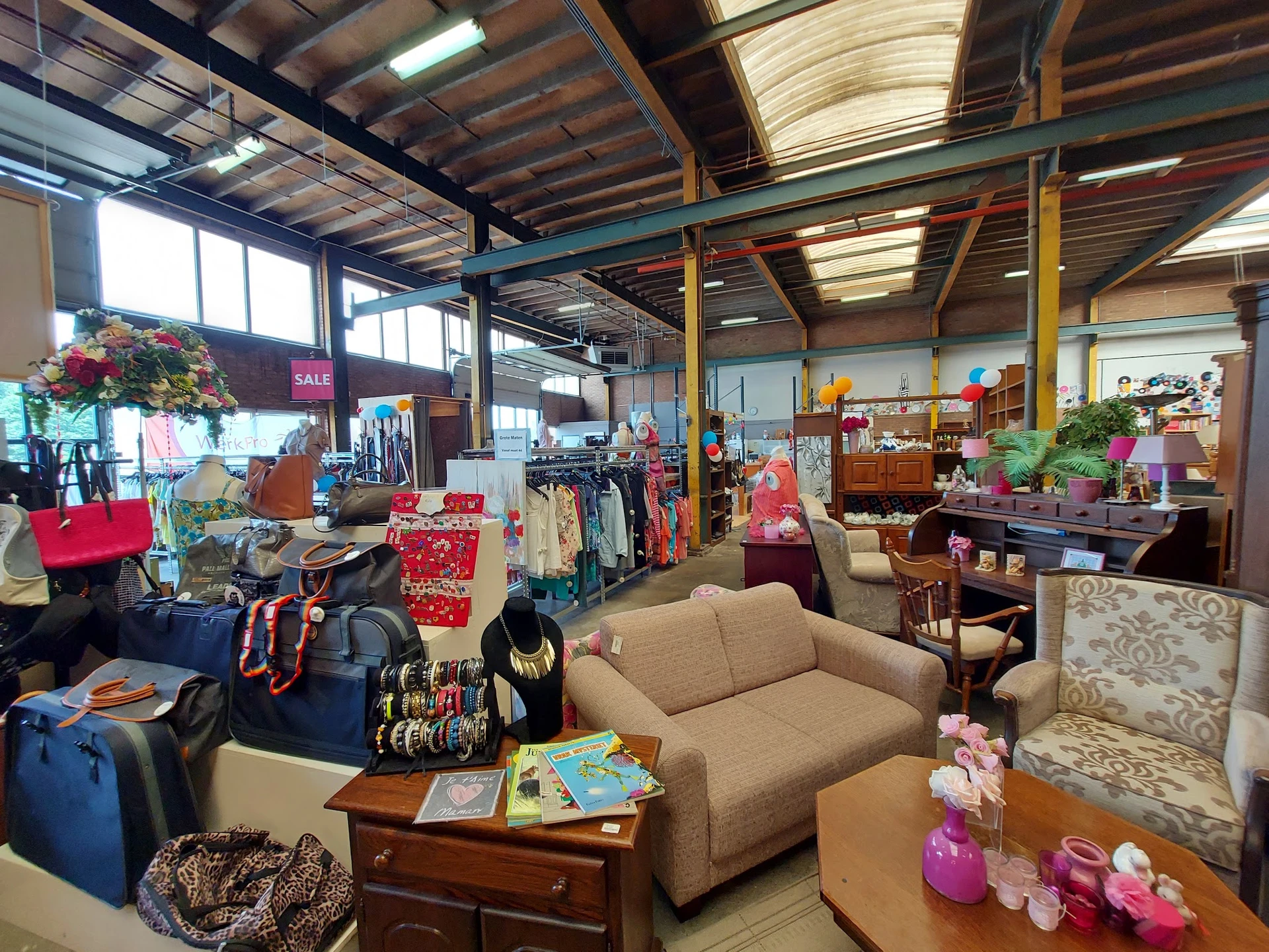 Winkelvloer met meubels, kleding, accessoires en huishoudartikelen in een kringloopwinkel