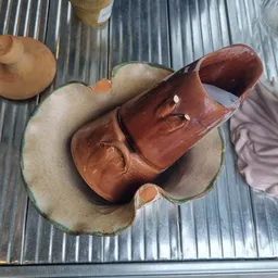 Bruinleren schoenen met ritssluiting op een grijs kussen, uitgestald in de winkel