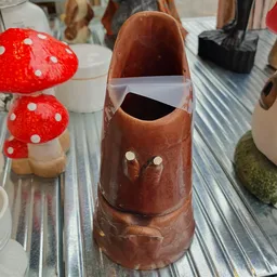 Handgemaakte chocolade paddenstoel met amandel-ogen, naast rode paddenstoelen met witte stippen