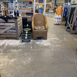 Winkelvloer met water, toonbanken, meubels en handelswaar in een kringloopwinkel