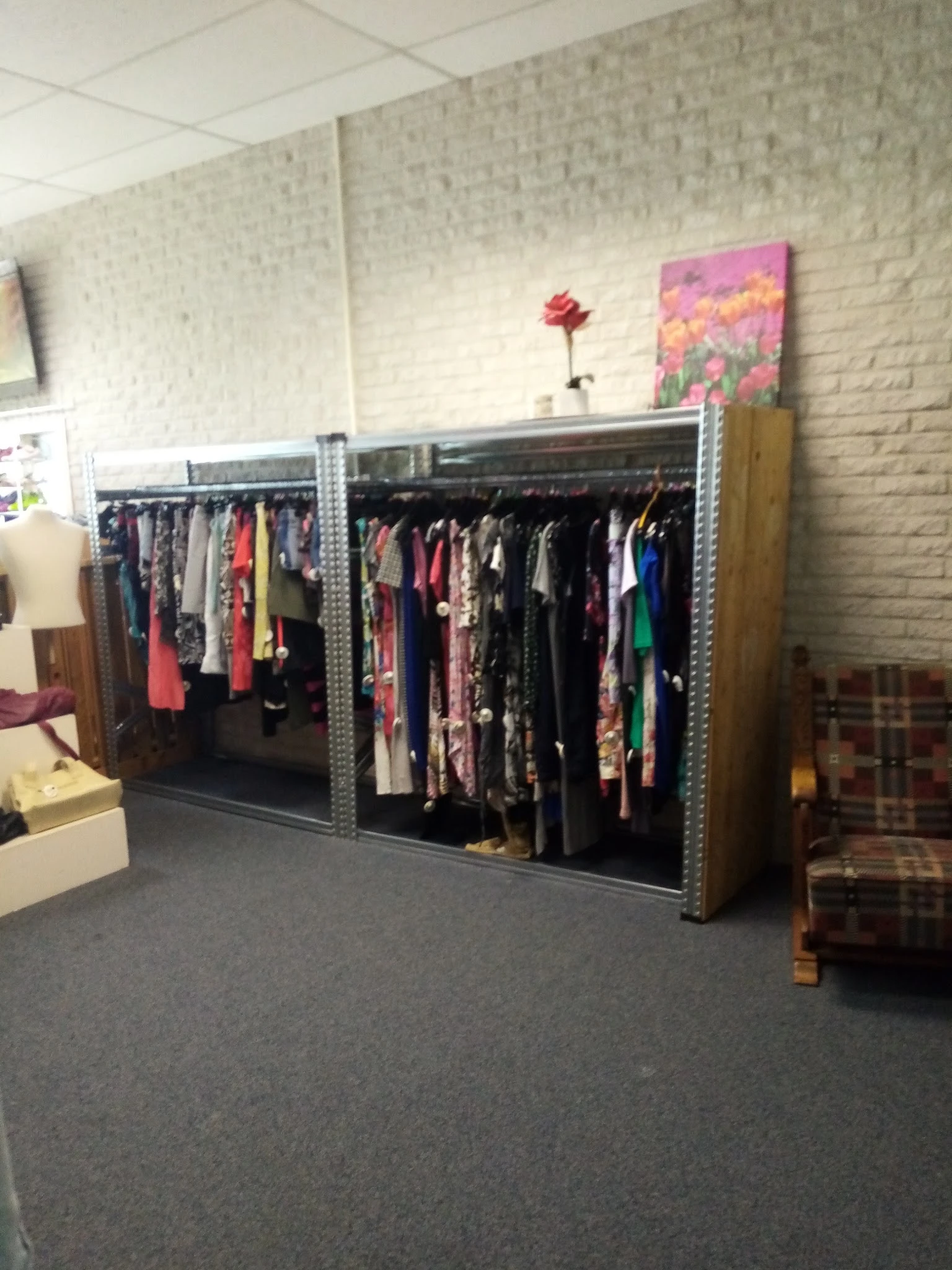 Metalen stellingen met grote hoeveelheid tweedehands kleding op hangers