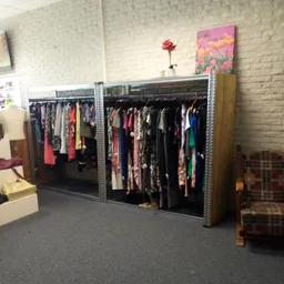 Metalen stellingen met grote hoeveelheid tweedehands kleding op hangers