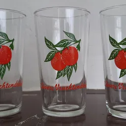 Drie glazen met rode tomaten en groene bladeren op het etiket