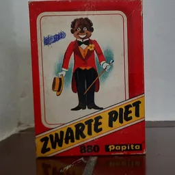 Vintage speelgoedverpakking van Zwarte Piet met figuur in rode jas en zwart pak