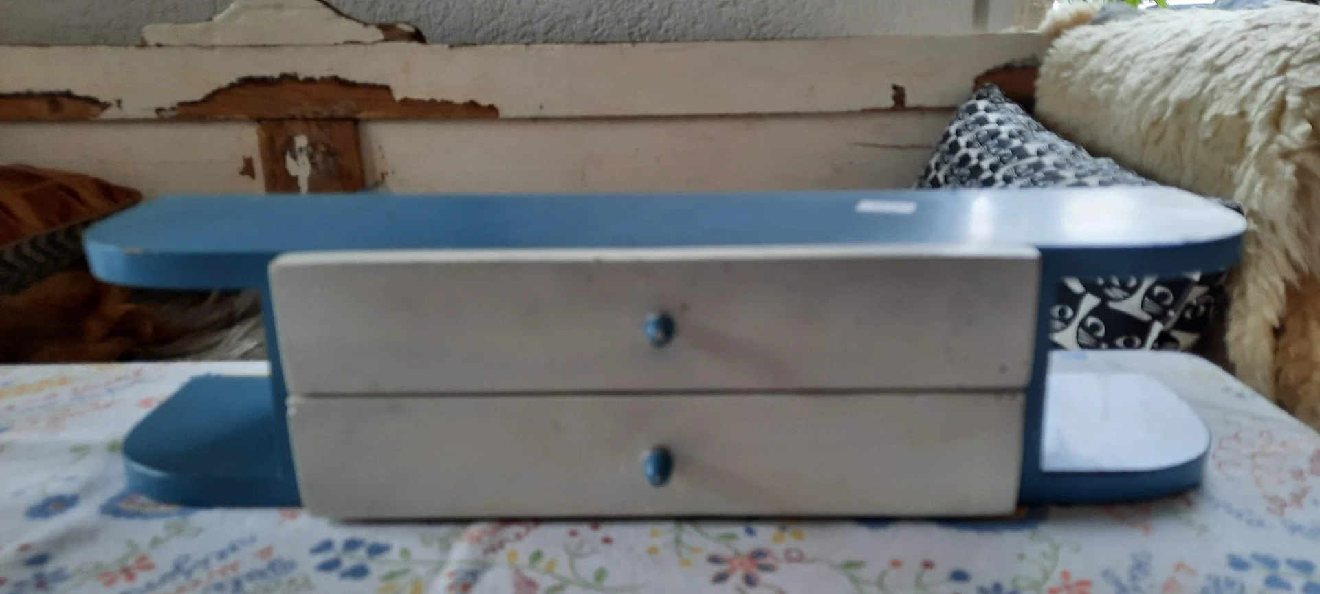 Wit nachtkastje met twee lades en blauwe knopjes