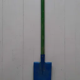 Blauwe spade met groene steel tegen witte wand