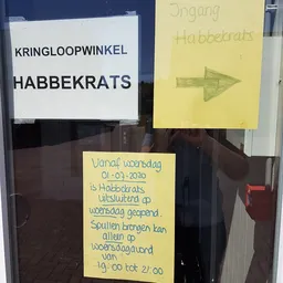 Winkelruit met papieren briefjes met geschreven tekst en een winkelnaambord