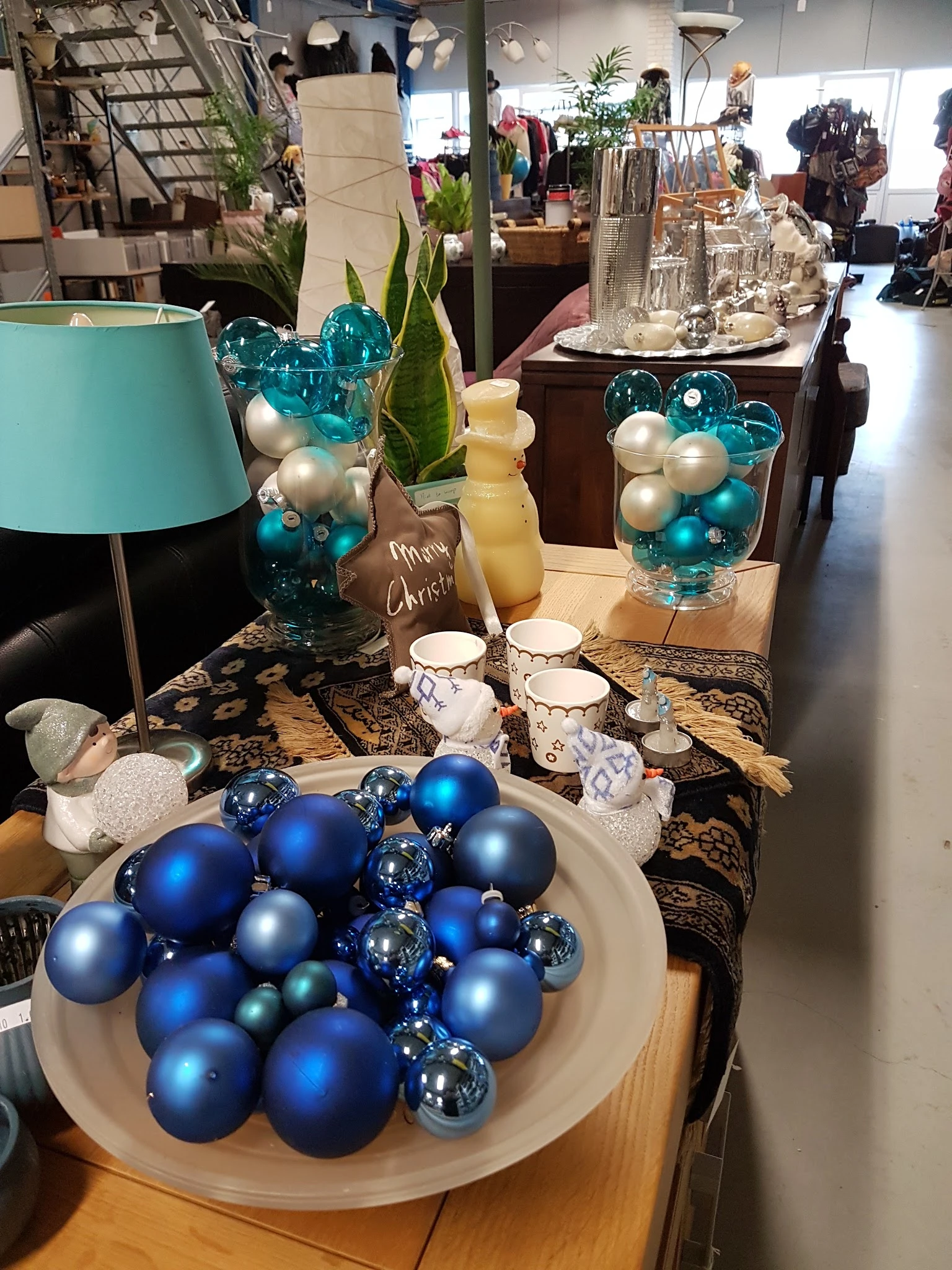 Kerst- en winterdecoratie met blauwe en witte kerstballen, lampen en accessoires op display