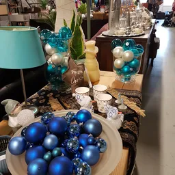 Kerst- en winterdecoratie met blauwe en witte kerstballen, lampen en accessoires op display