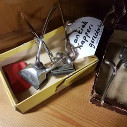 Close-up van zilverkleurige kappersgereedschappen in een gele doos met een wit label
